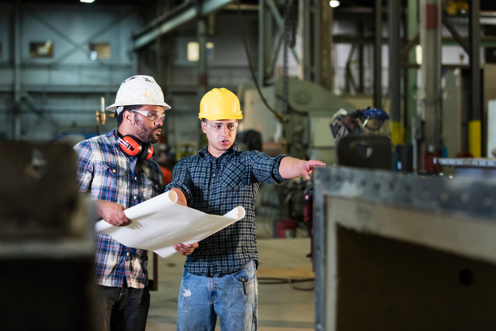 Multi-ethnic workers talking in metal fabrication plant